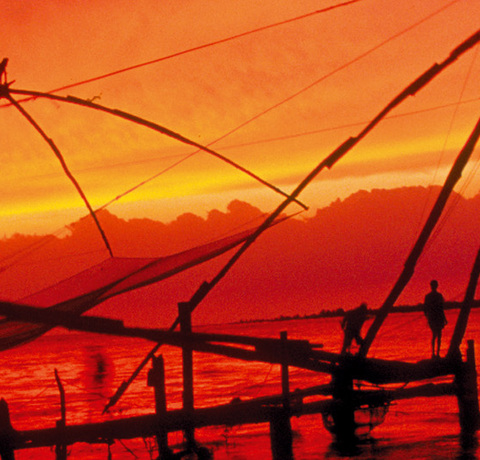 Sonnenuntergang über den Chinesischen Fischernetzen in Cochin auf einer Indien Reise