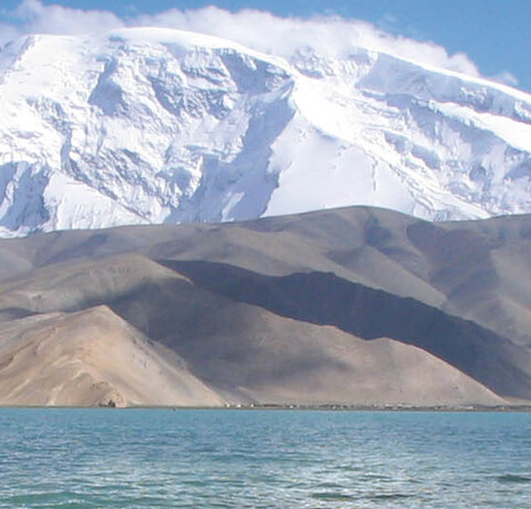 Berg Mustag Ata mit Karakol See Schneebedeckter Berg Mustag Ata mit dem Karakol See im Vordergrund