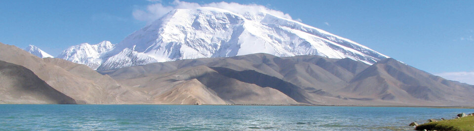 Berg Mustag Ata mit Karakol See Schneebedeckter Berg Mustag Ata mit dem Karakol See im Vordergrund