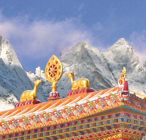 Eingangsportal des Tengboche Klosters in Nepal mit schneebedeckten Bergen im Hintergrund