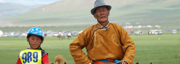 Pferdezüchter mit einem Kinderjockey in der Mongolei