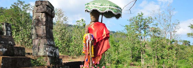 Geschmückter Buddha mit grünem Sonnenschirm am Tempel von Wat Phou in Laos