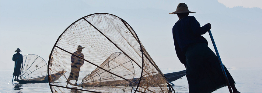 Einbeinruderer mit Booten und Fischernetzen auf dem Inle See in Myanmar