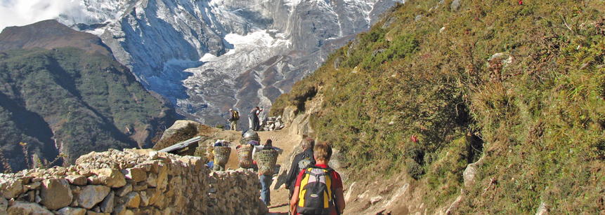 Wanderer und Sherpas auf einem Wanderweg im Everest Gebiet auf einer Nepal Reise