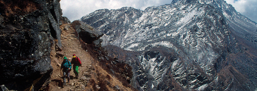 Zwei Wanderer auf einem steinigen Trekkingpfad umgeben von Bergen auf einer Nepal Reise durch Helambu und Langtang