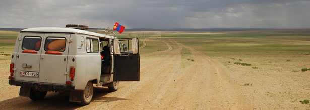 Furgon Geländebus mit mongolischer Fahne am Dachgepäckträger auf einer Pisten Straße in der Mongolei