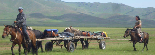 Nomade auf einem Pferd mit Pferdekarren mit Gepäck von Trekking Gästen auf einer Mongolei Reise