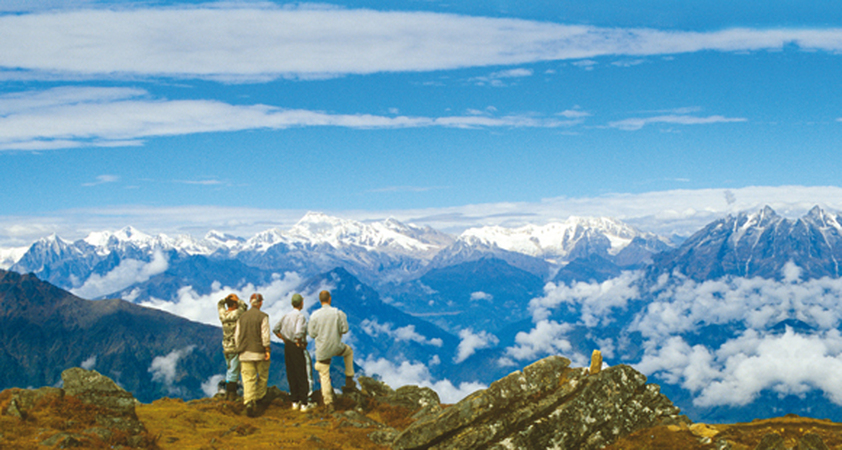 Wanderer stehen auf einem Aussichtspunkt und schauen auf das Langtang Tal in Nepal mit den Bergen des Himalaya am Horizont