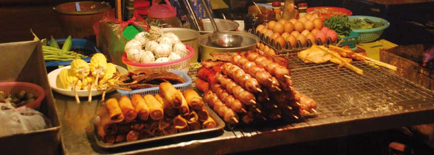 Essens Stand auf dem Nachtmarkt in Vientiane in Laos mit Frühlingsrollen, gekochtem Mais, Fleischspießen und Eiern