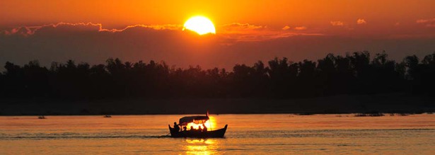 Sonnenuntergang in Kratie am Ufer des Mekong in Kambodscha mit einem Boot auf dem Fluss