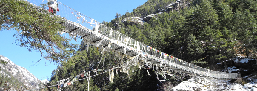 Mit Gebetsfahnen geschmückte Hängebrücke im Everest Gebiet in Nepal