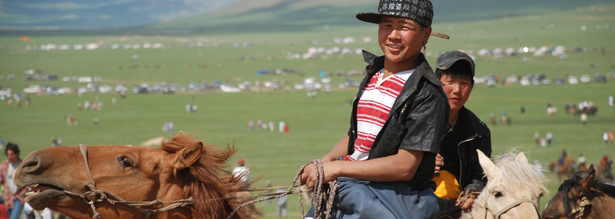 Ein mongolischer Nomaden Junge beim Reiten auf dem Naadam Fest in der Mongolei