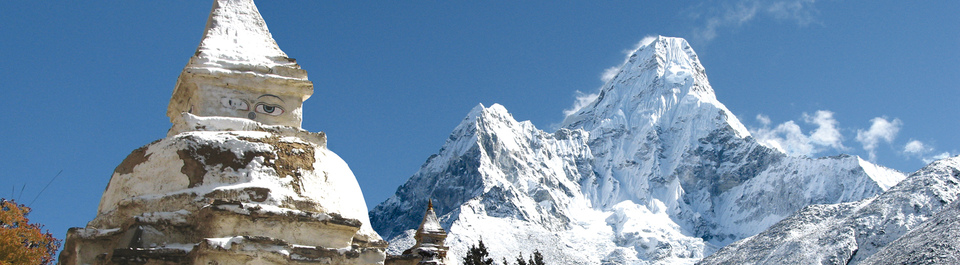 Aussicht auf den schneebedeckten Berg Amadablam mit einer Stupa im Vordergrund auf einer Trekking Reise in Nepal