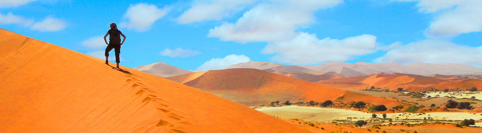 Reisegast wandert auf eine Sanddüne im Sossusvlei in Namibia